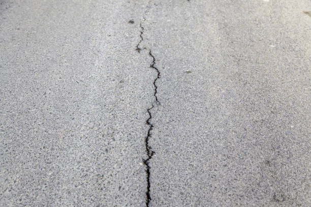 Concrete surface with a narrow crack needing repair and maintenance